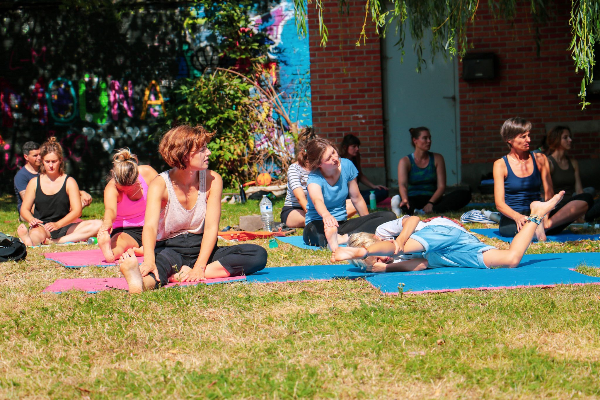 Deelnemers doen yoga op grasveld