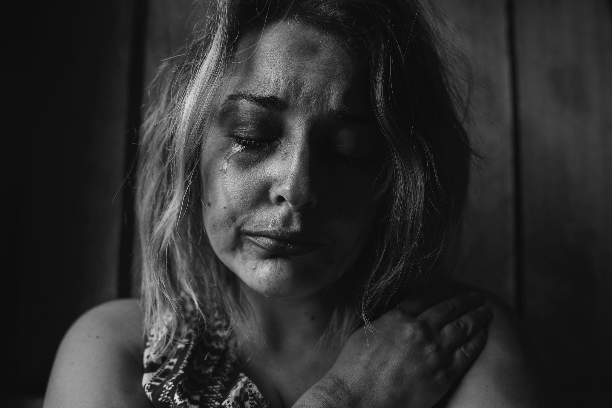 Zwart-wit portret van huilende vrouw.